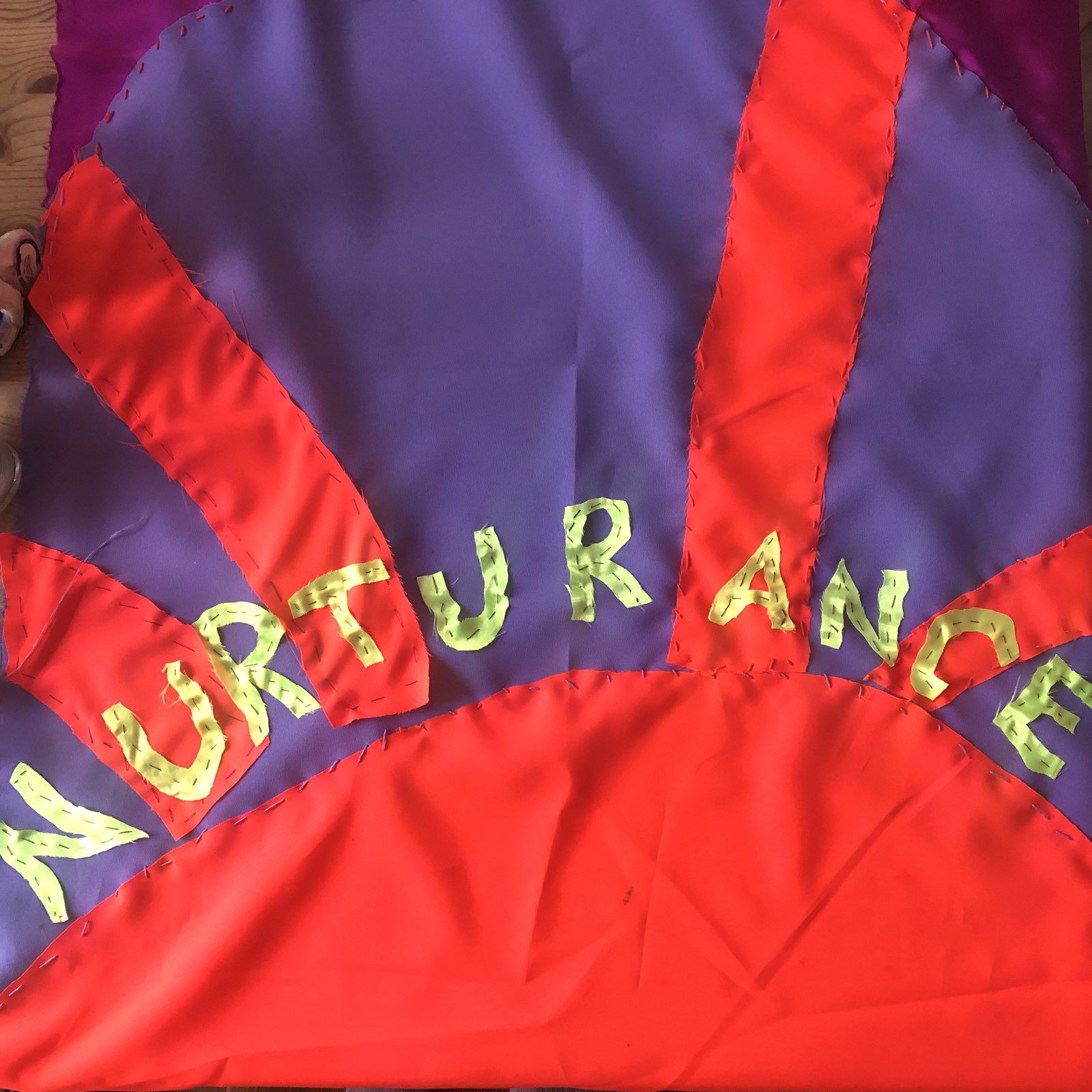 A red and purple stitched banner reading 'nurturance'