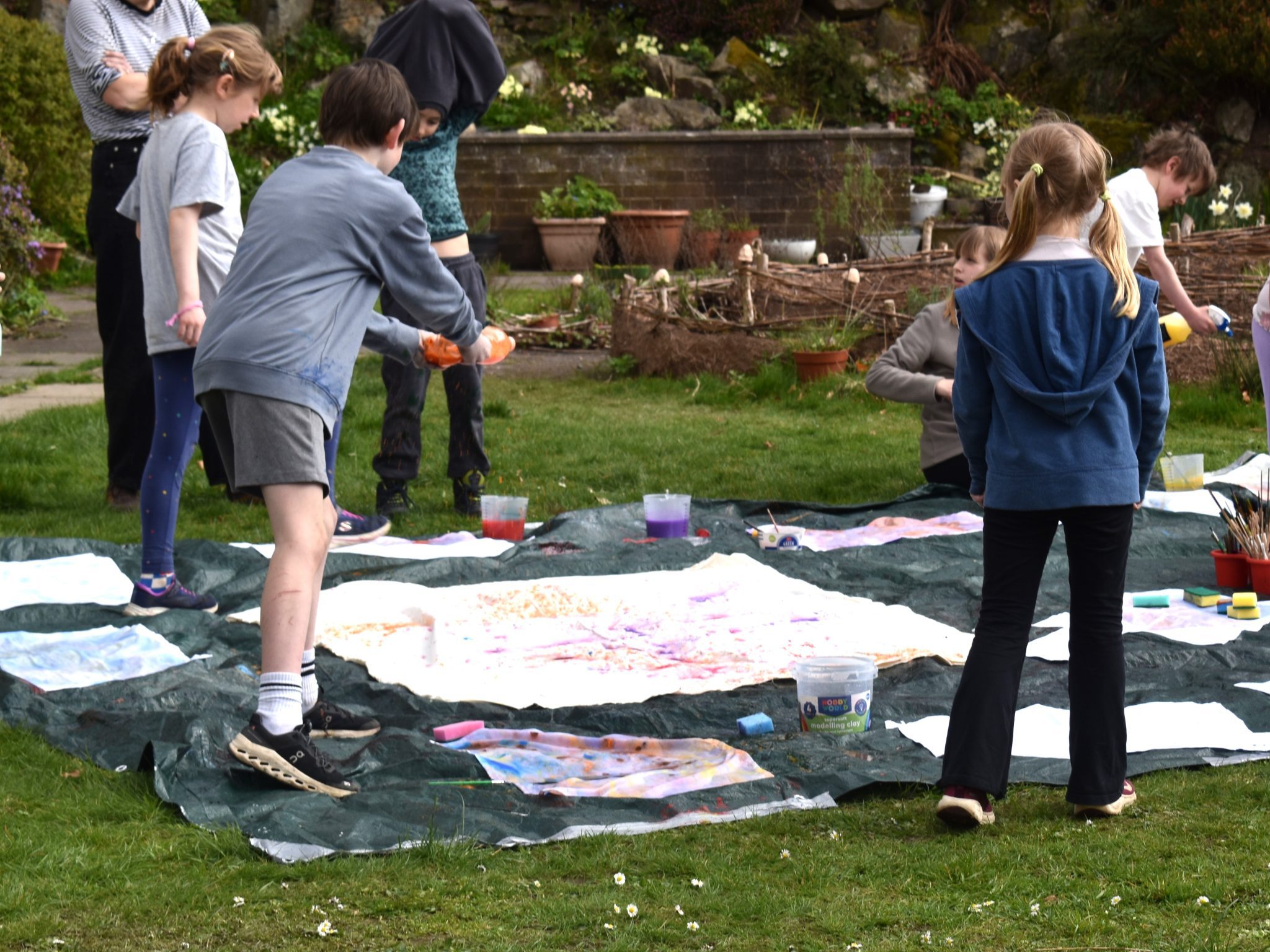 A group of children outside splattering paint