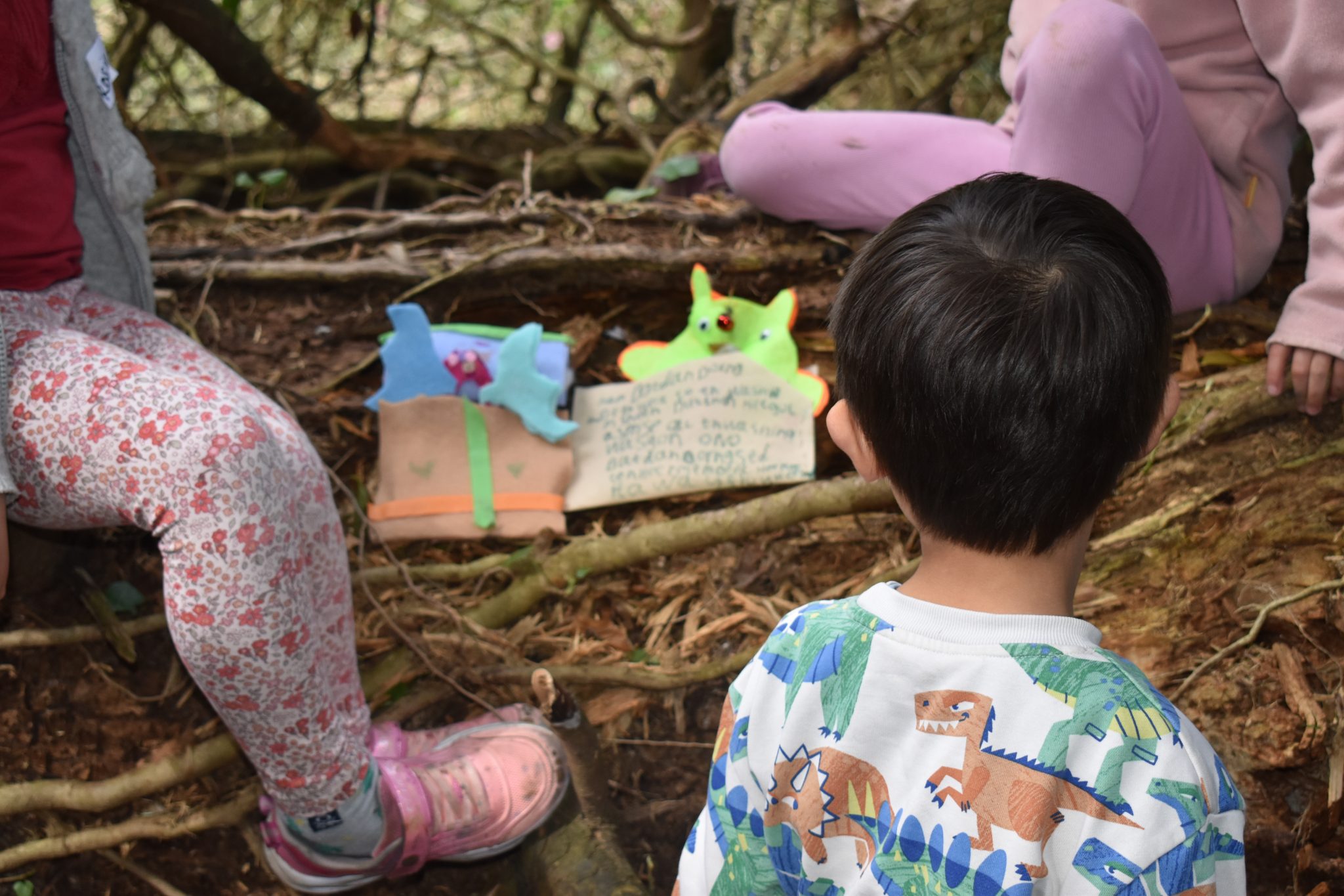 Children looking at felt monsters in the garden
